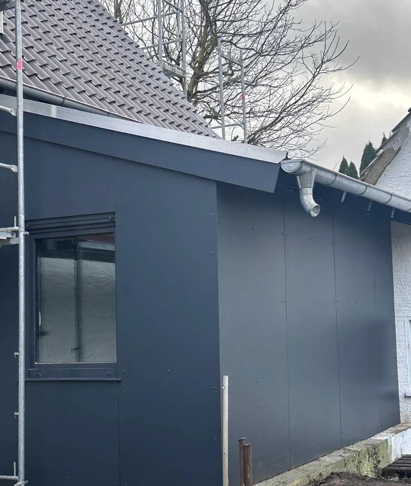 Anthrazitfarbene Fassadenverkleidung mit sauberem Dachabschluss